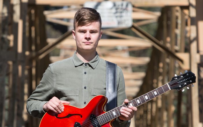 man holding red guitar