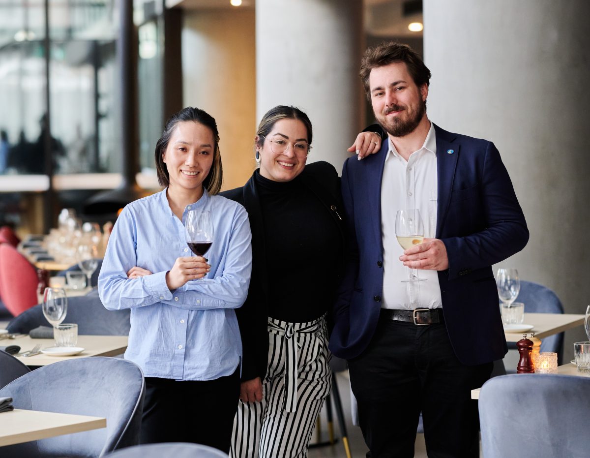 three people standing in restaurant