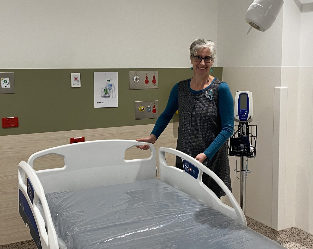 woman standing next to a hospital bed