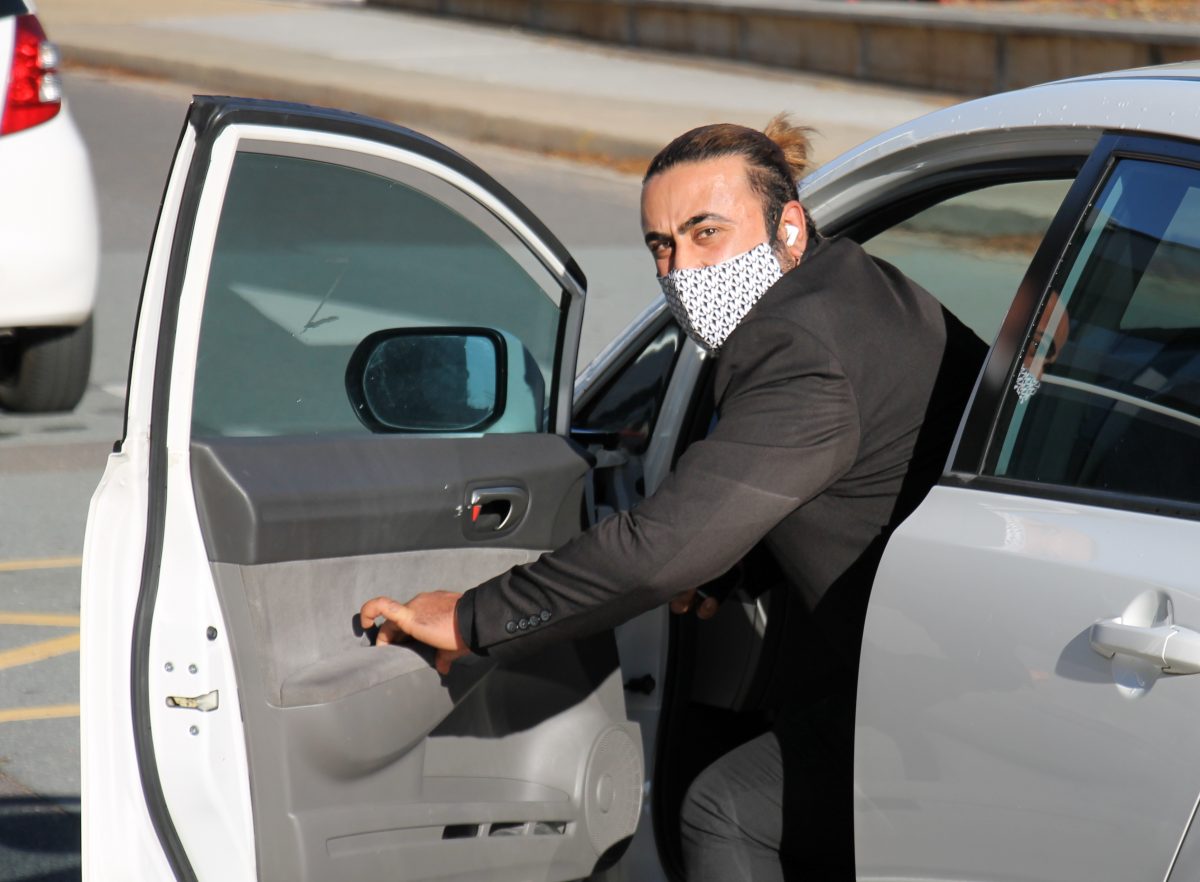 man wearing a mask getting out of a car