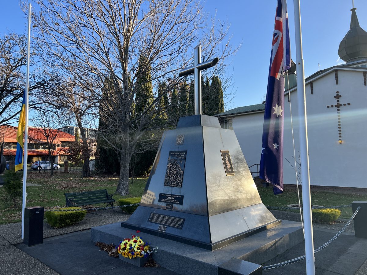 A memorial to Holodomor which stands in front of the Ukrainian Orthodox Church in Turner, with an Australian and Ukrainian flag on either side.