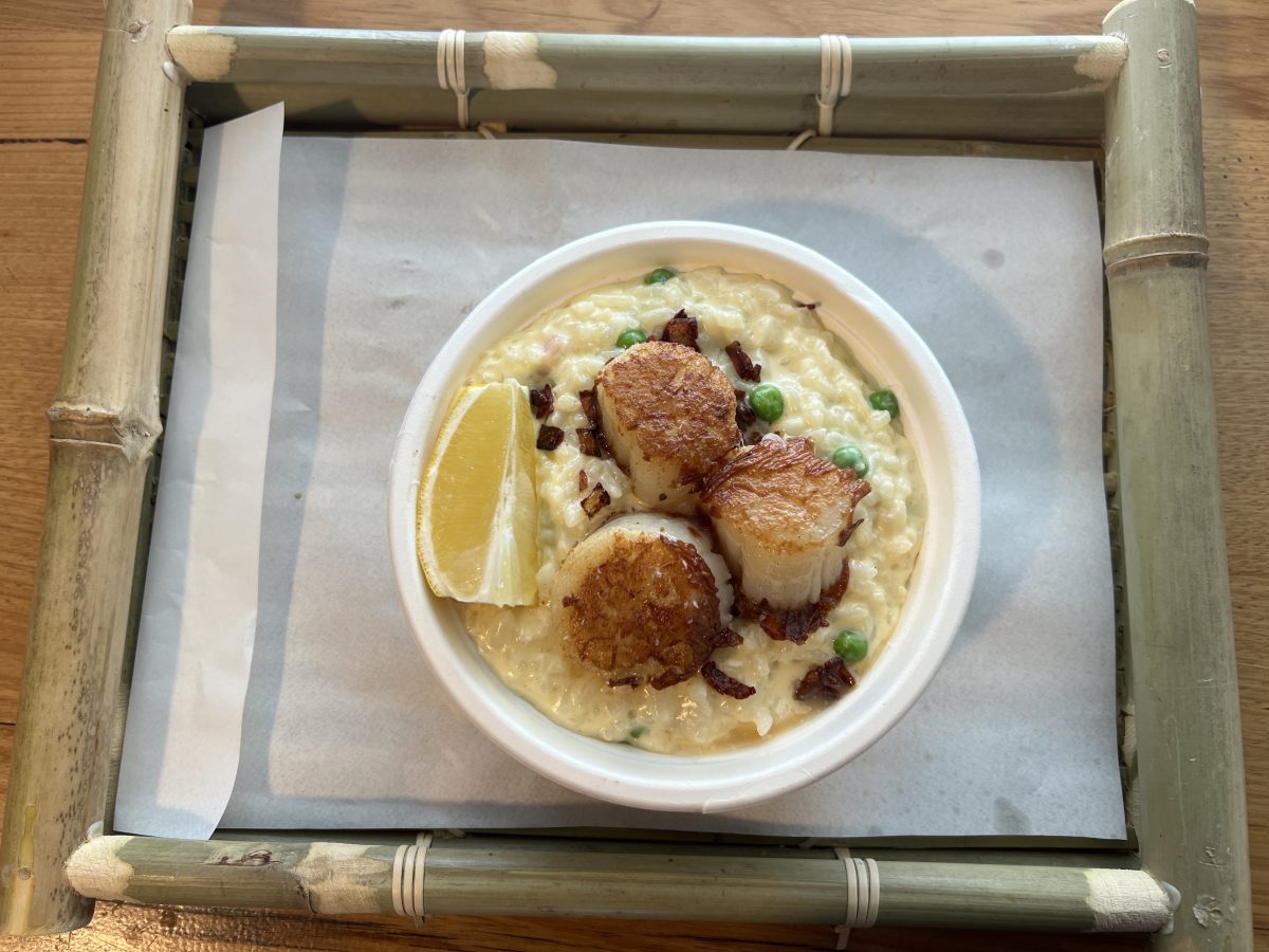 A bamboo tray with a bowl of risotto in the middle.