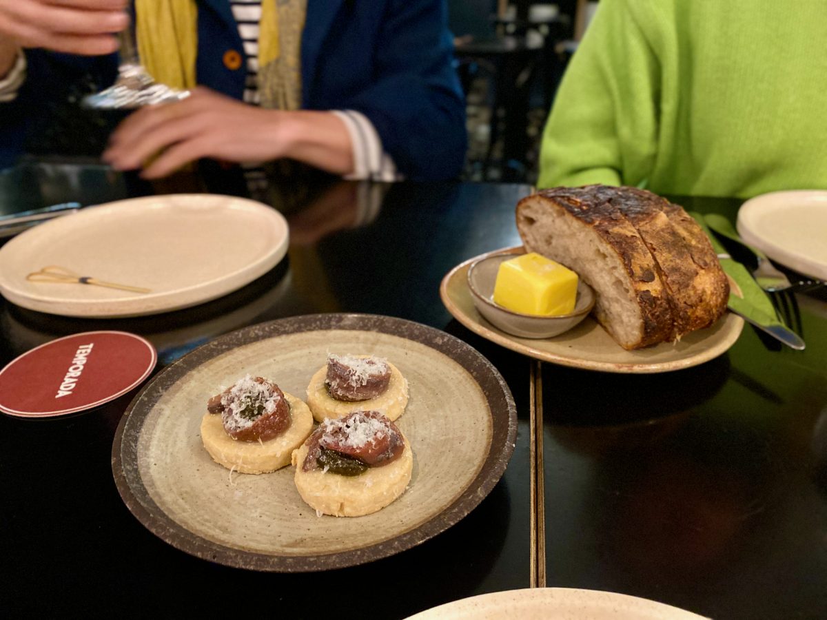 bread and butter with snack dish of anchovies in foreground