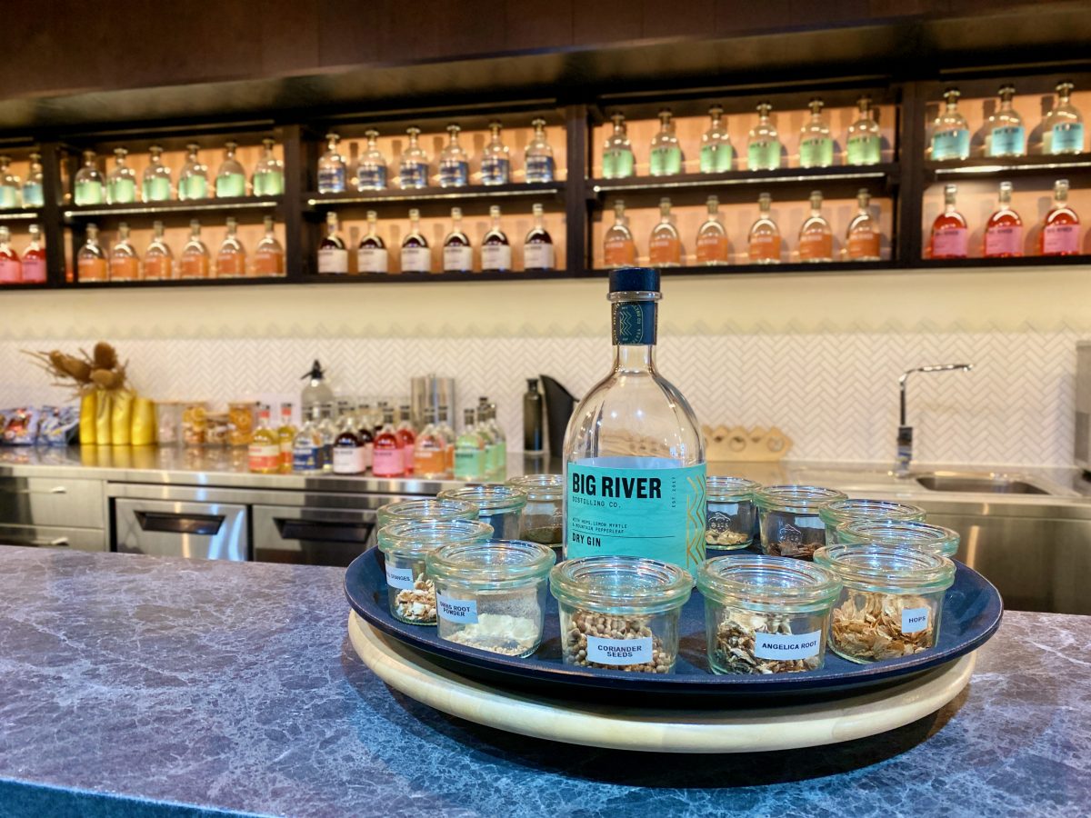 Bottle of gin surrounded by small jars of botanicals