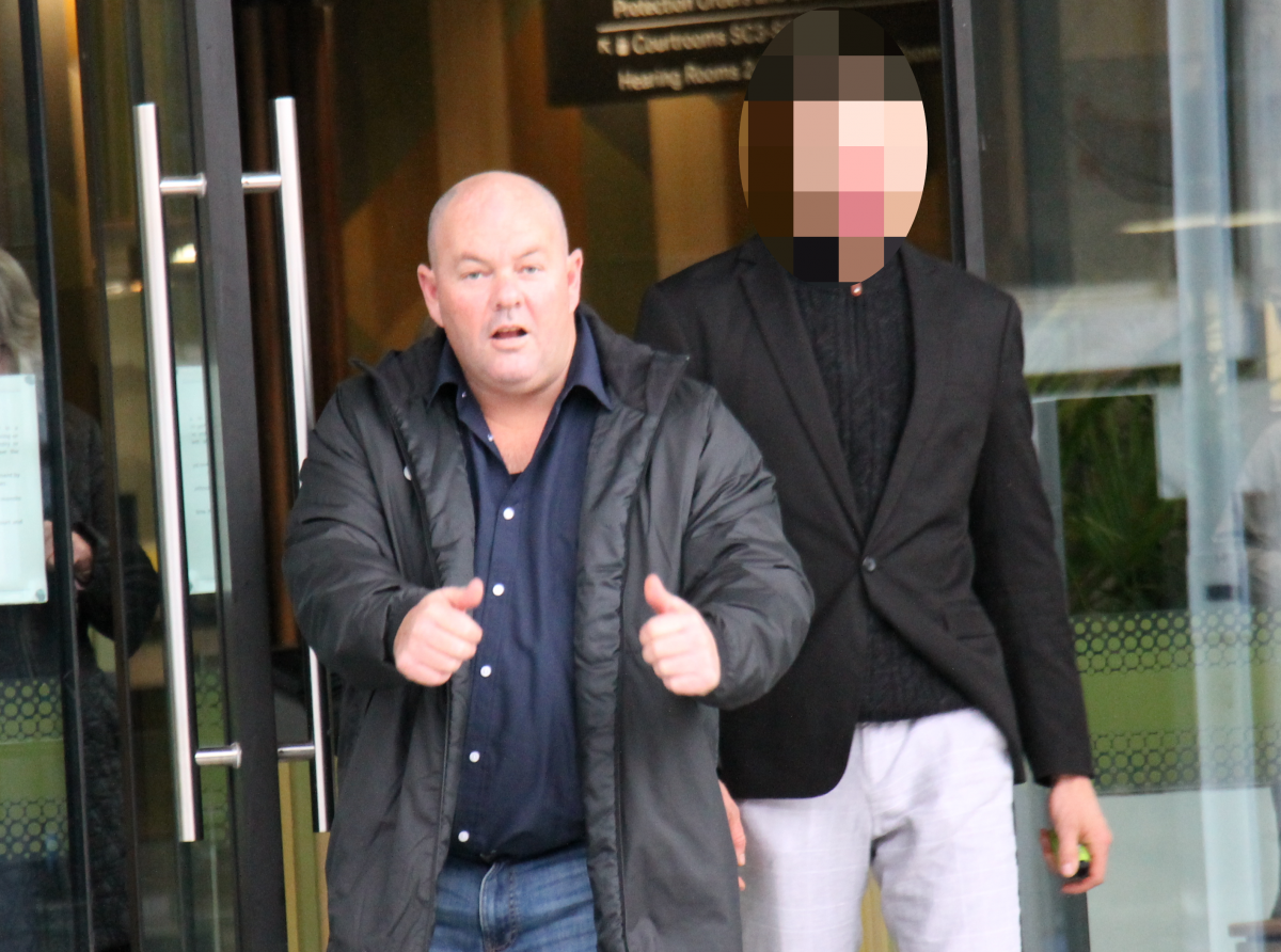 man gives a thumbs up to camera as he leaves court