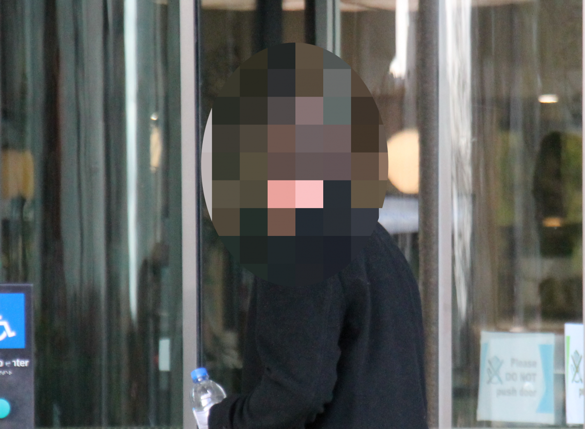 man with pixellated face enters court