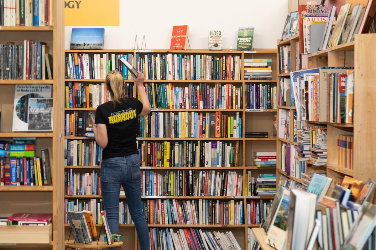 Person putting books on a bookshelf