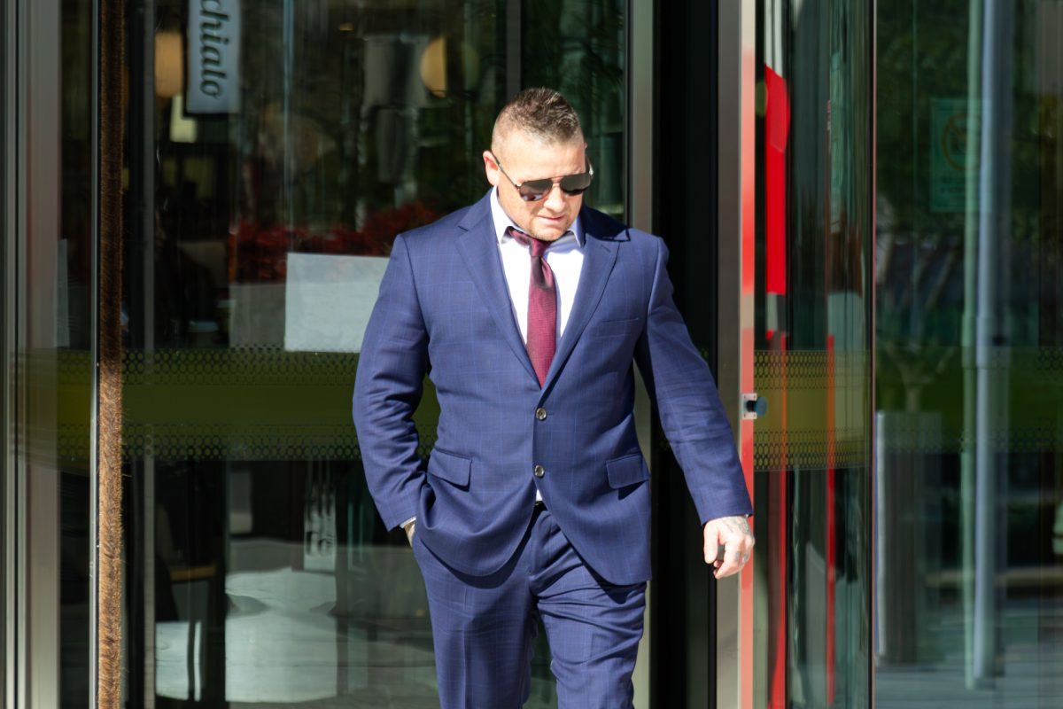 man in suit and sunglasses leaving court