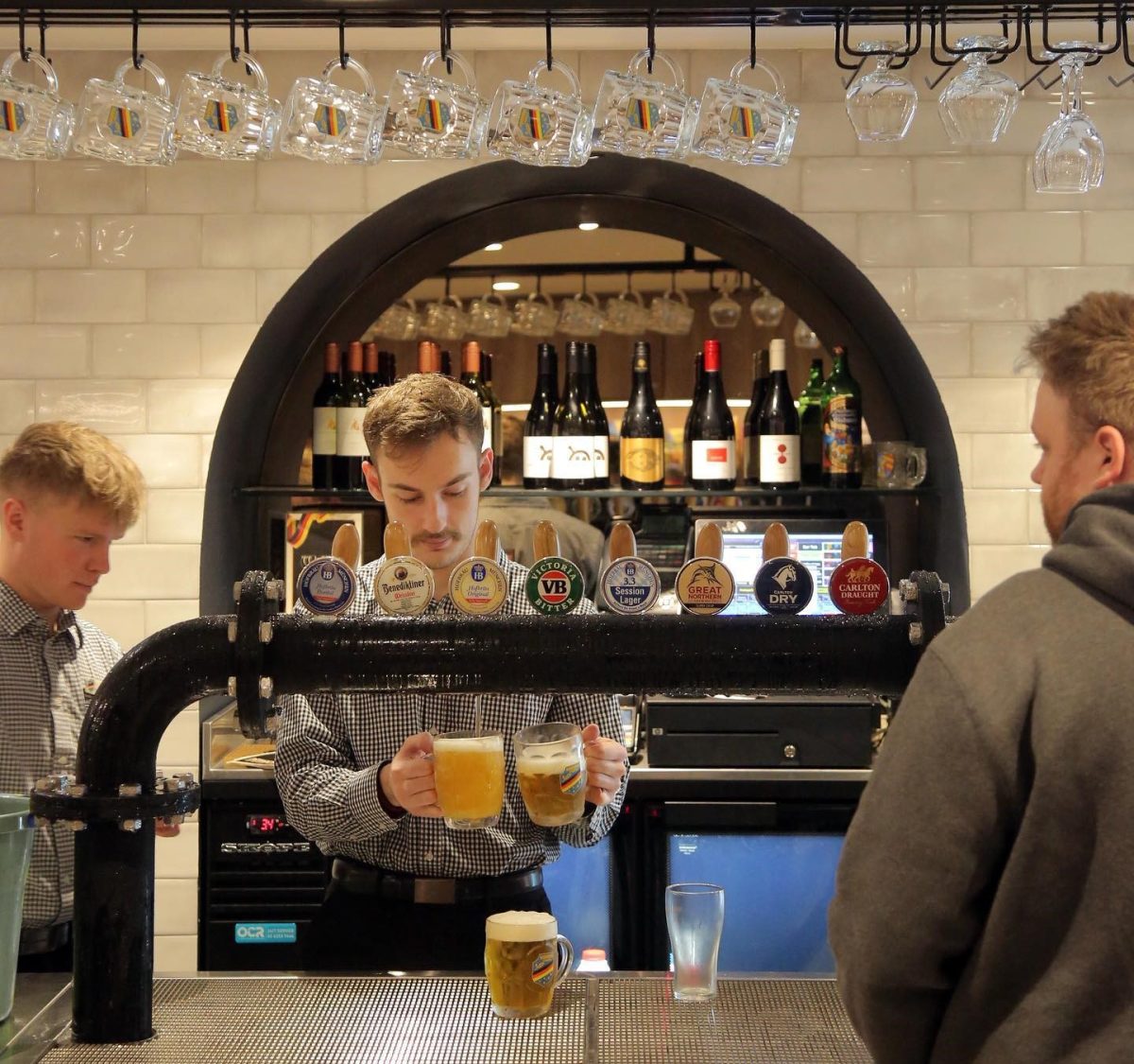 male bar attendant pouring beer