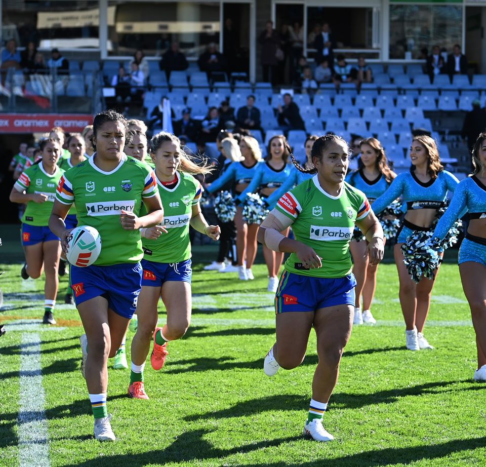 The Raiders NRLW side running onto the field in their first game of the season. 