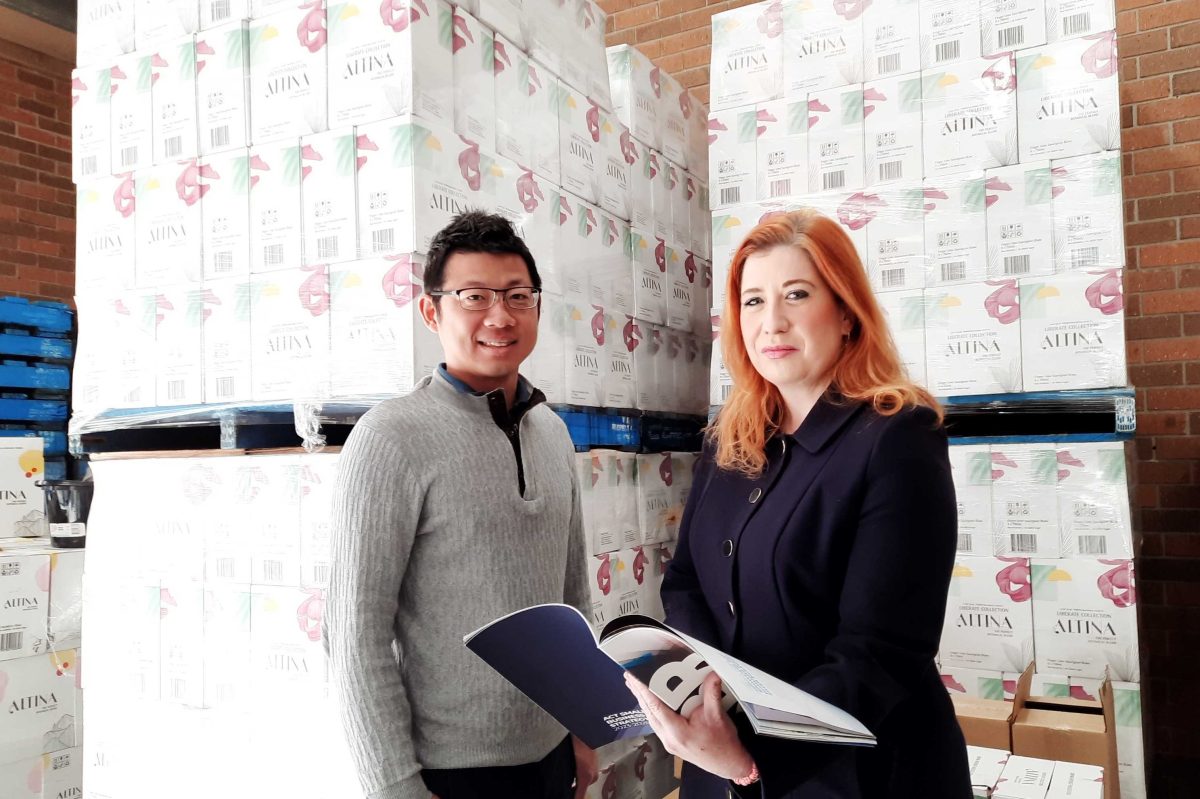 man and woman holding book in warehouse