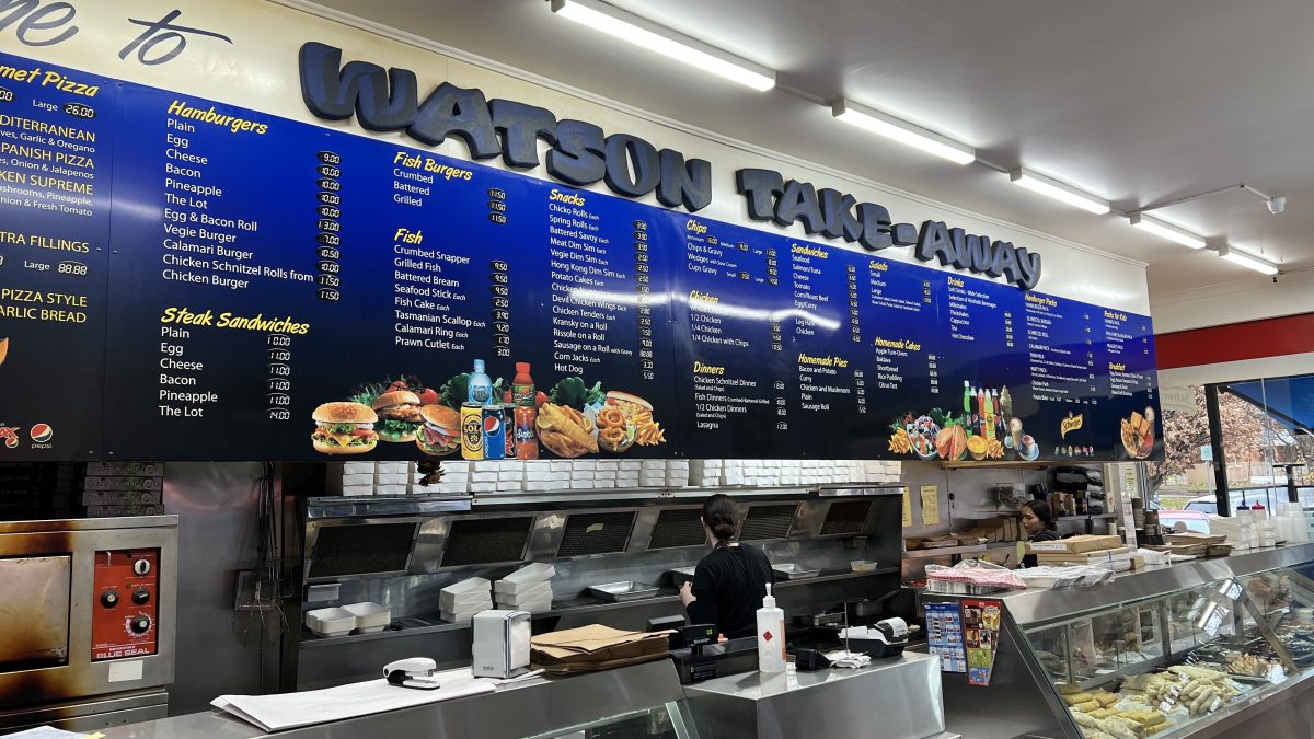 Watson Takeaway counter with the kitchen behind, and a menu board above.