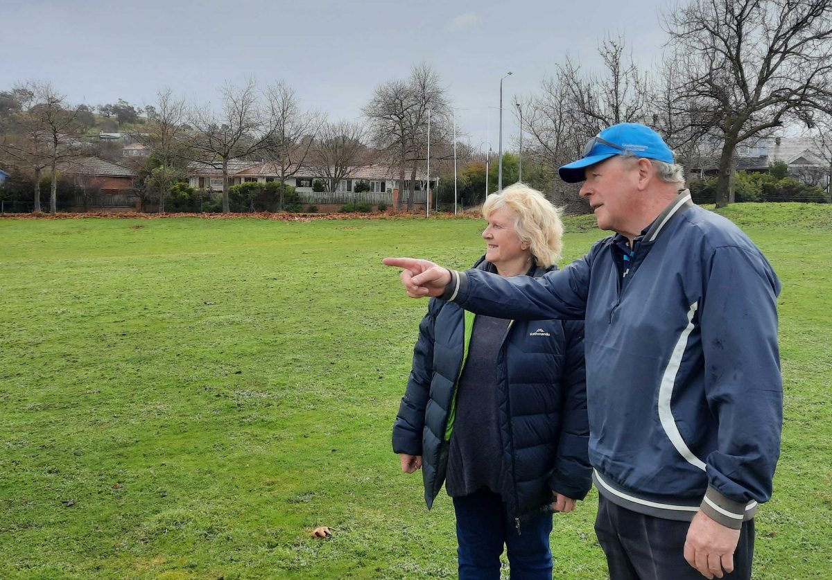 man and woman standing in field