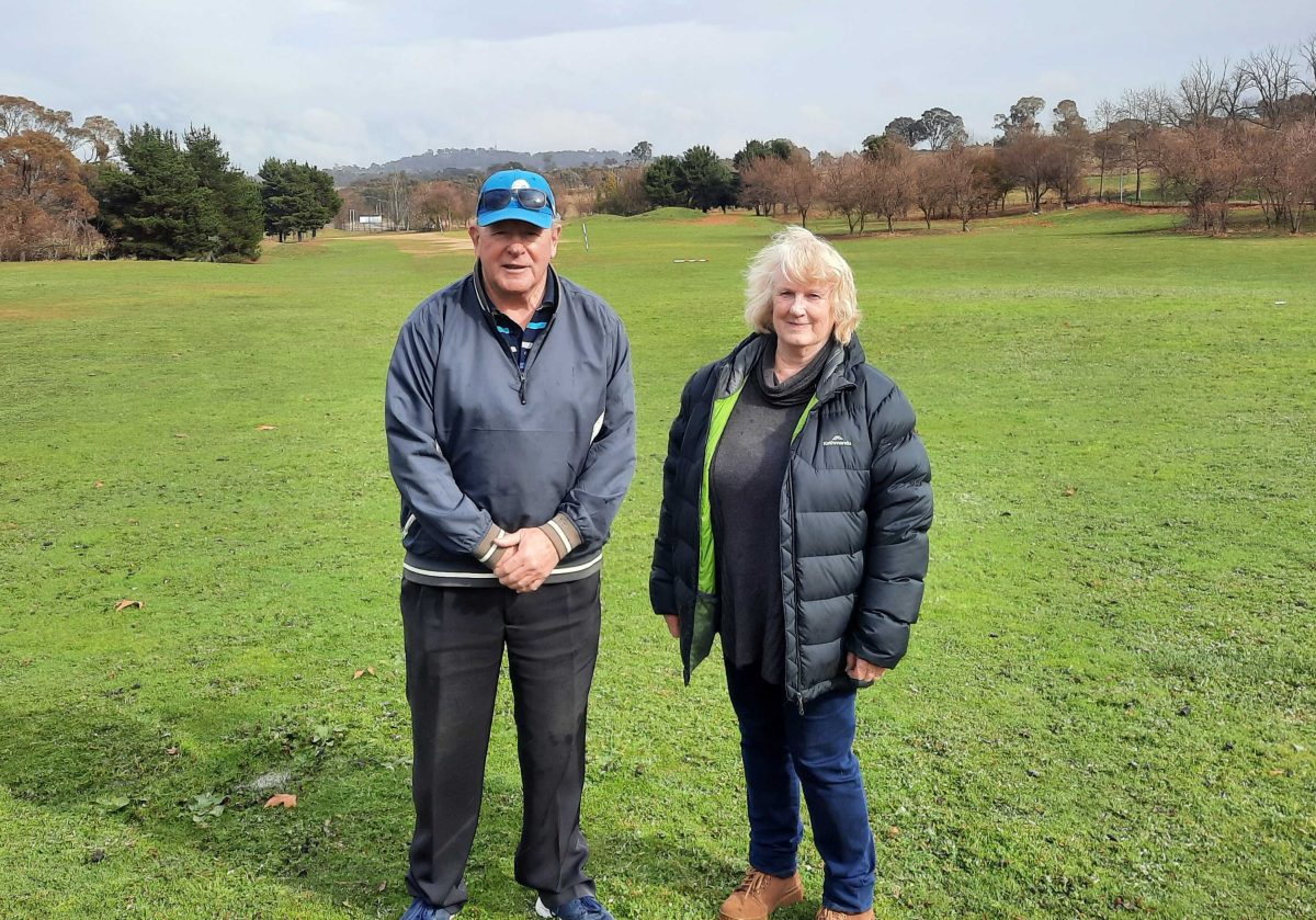 man and woman standing in field