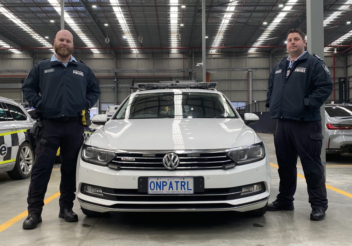 police officers either side of a patrol car