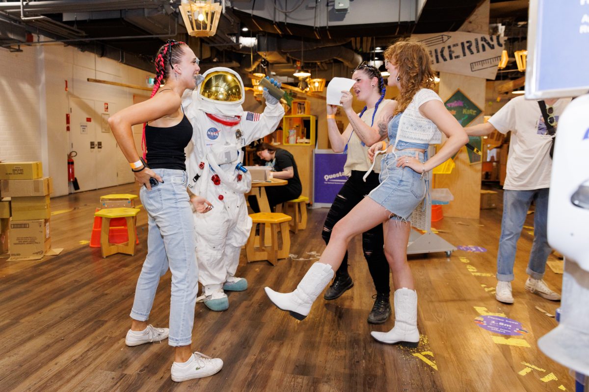 A group dance with a person in an astronaut costume.
