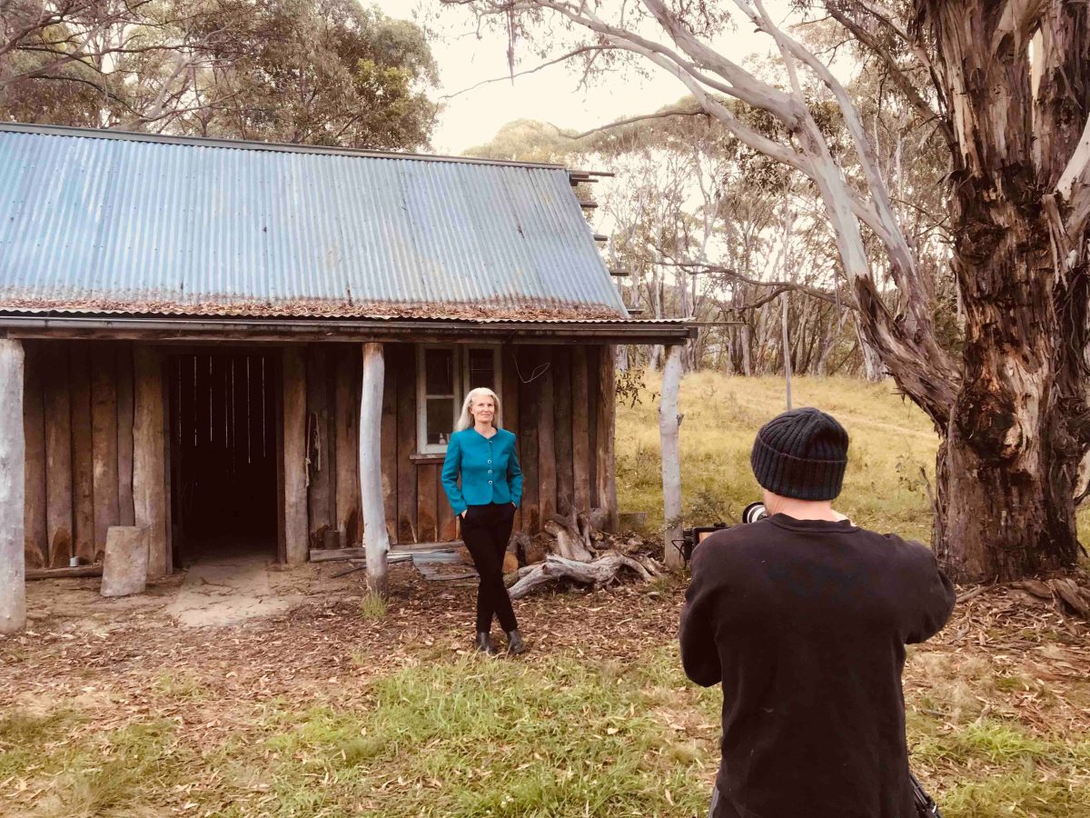 Photographer shoots actor Isabelle Faure outside hut.