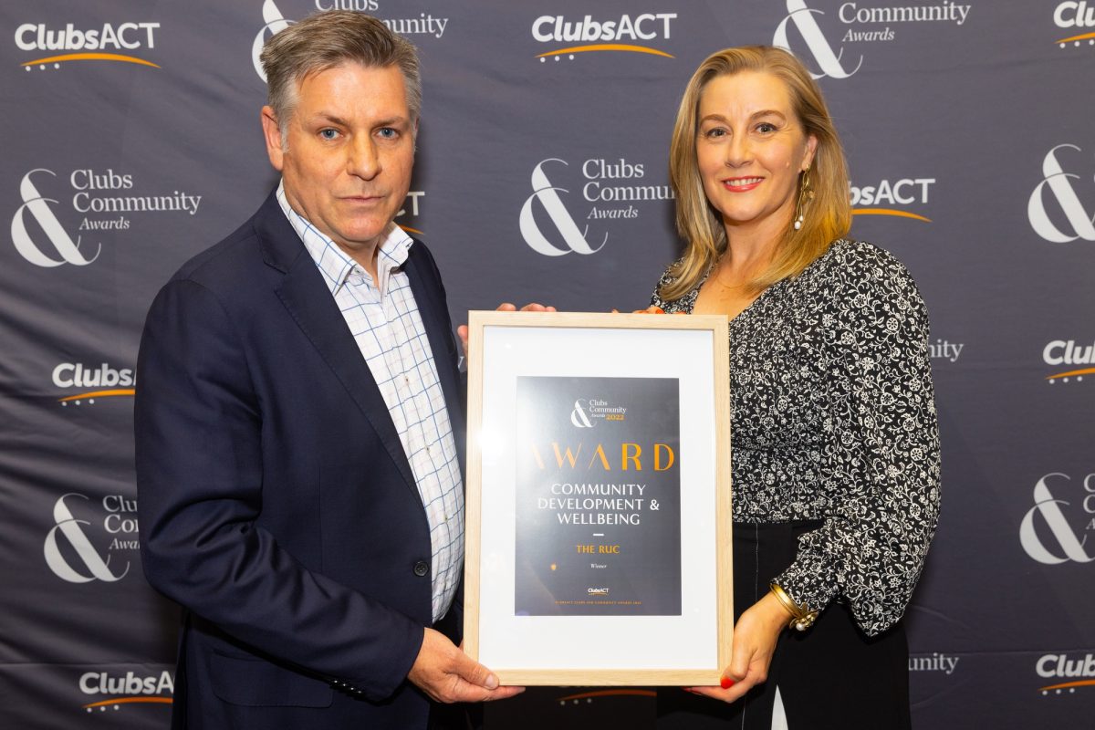Craig Leseburg and Alisa Taylor stand holding community development and wellbeing award
