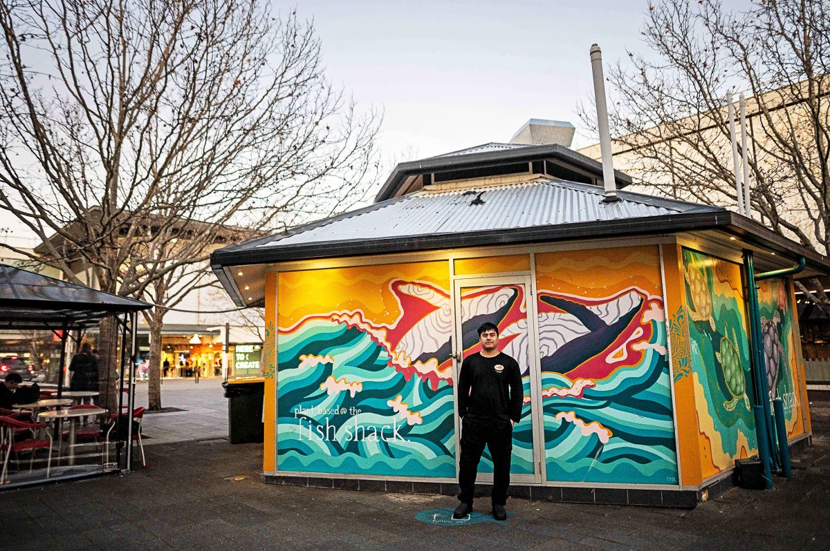 a man stands in fron of a restaurant