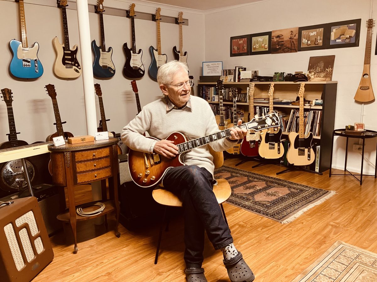 Man sitting down playing electric guitar