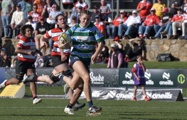 female rugby player running for a try