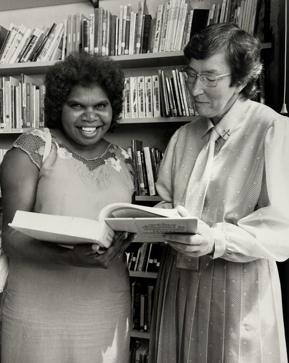 A young Indigenous woman reads with a member of the Dominican order on Canberra's Signadou campus.