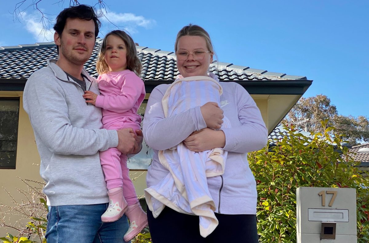 man holding young daughter and woman holding baby son