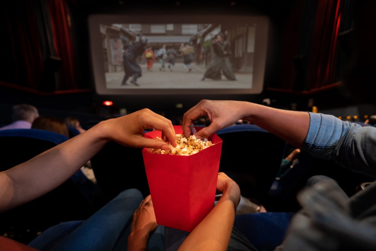 hands and box of popcorn