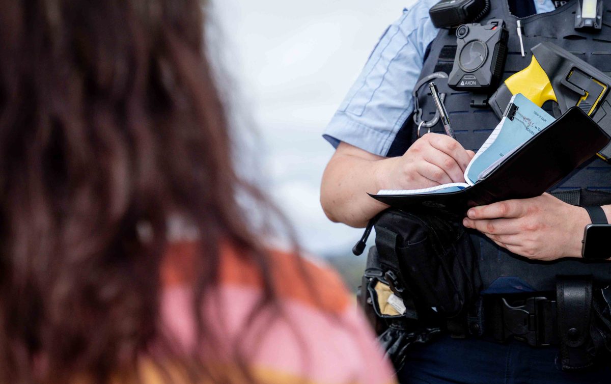 anonymous person speaking with police officer, who is taking notes.