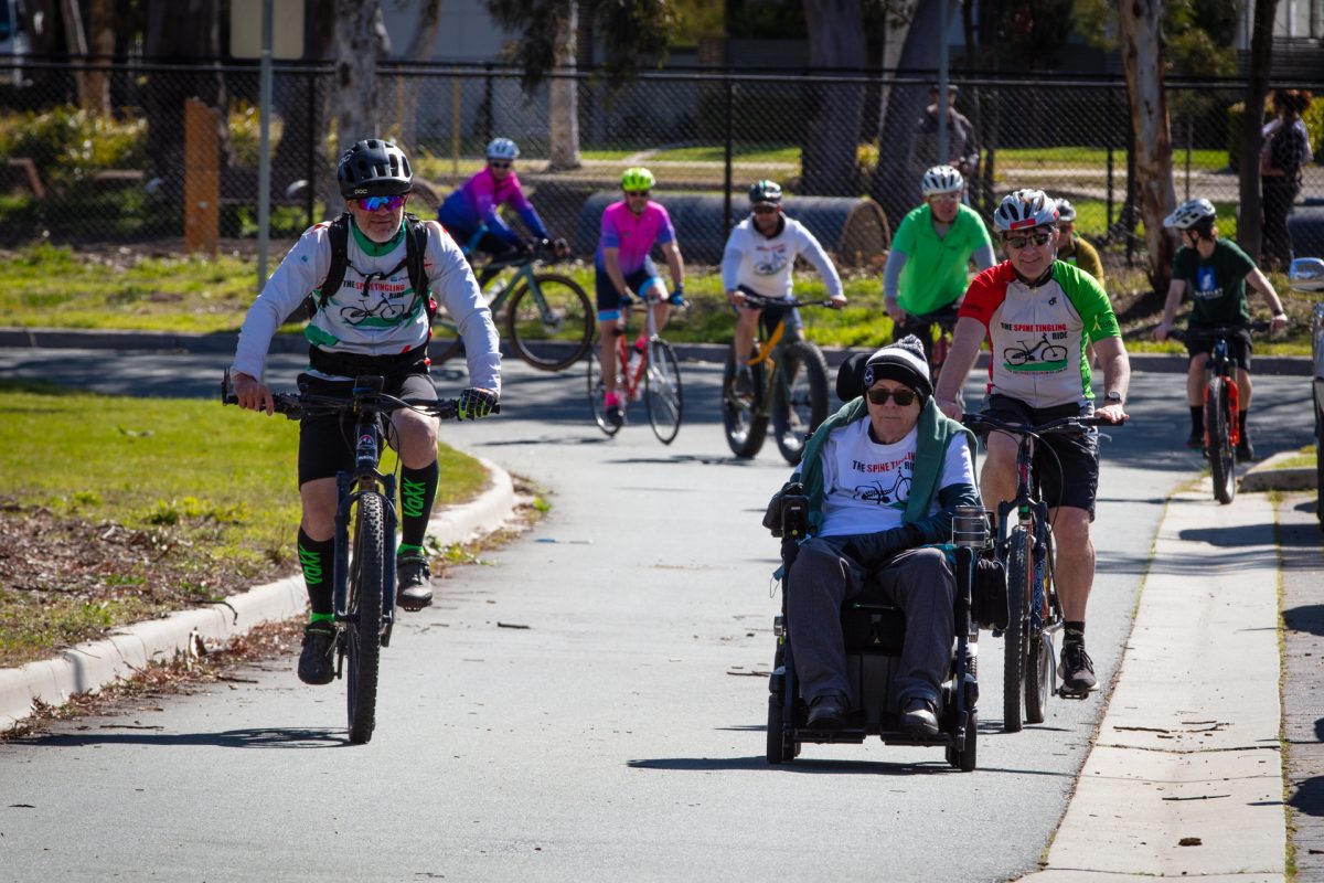 man cycling next to man in a wheelchair