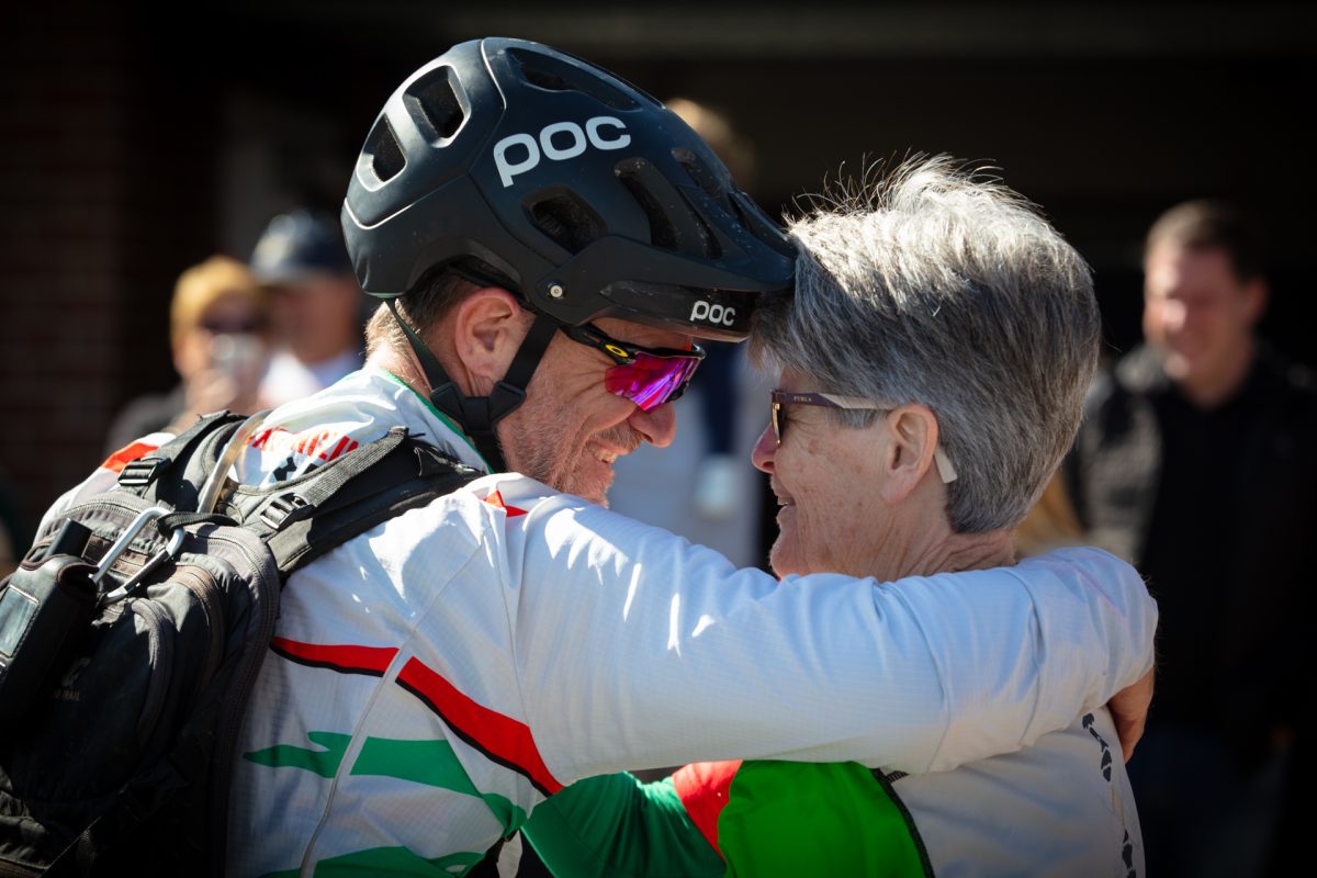 man in bike helmet hugging a woman