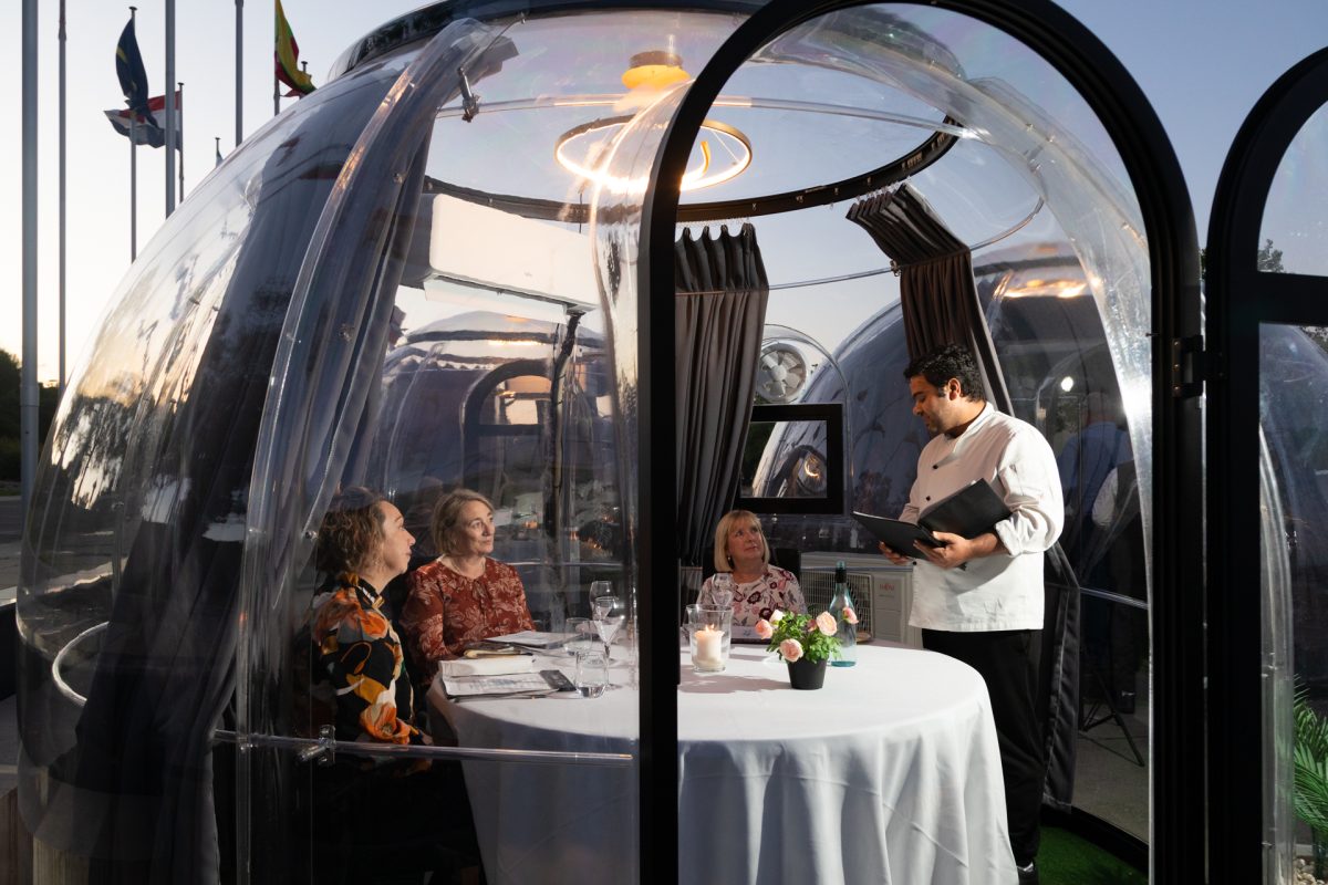 A chef serves customers in a dining dome.