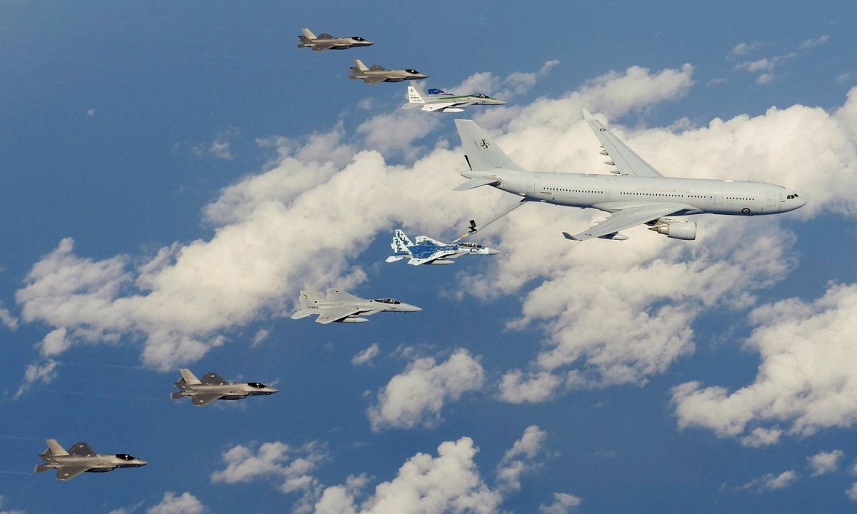 RAAF F-35A and JASDF F-35As and F-15Js in formation behind an RAAF KC-30A tanker transport over the Sea of Japan while an F-15J refuels.