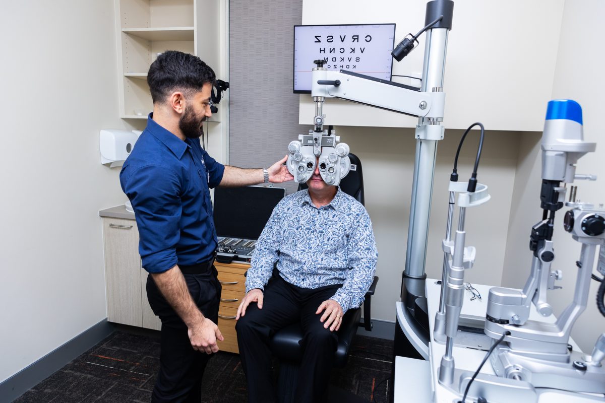 UC Master of Optometry student Esman Ayan takes Scott Yates through an eye test