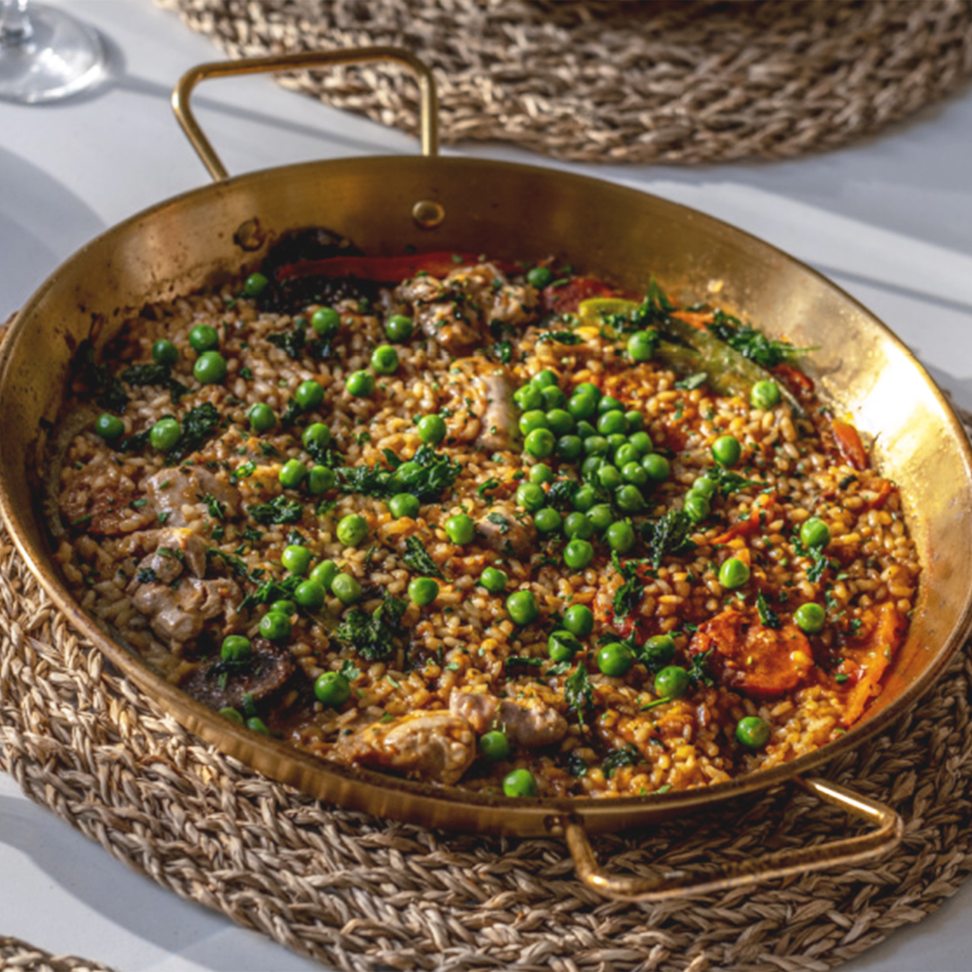 Large dish of paella with peas.