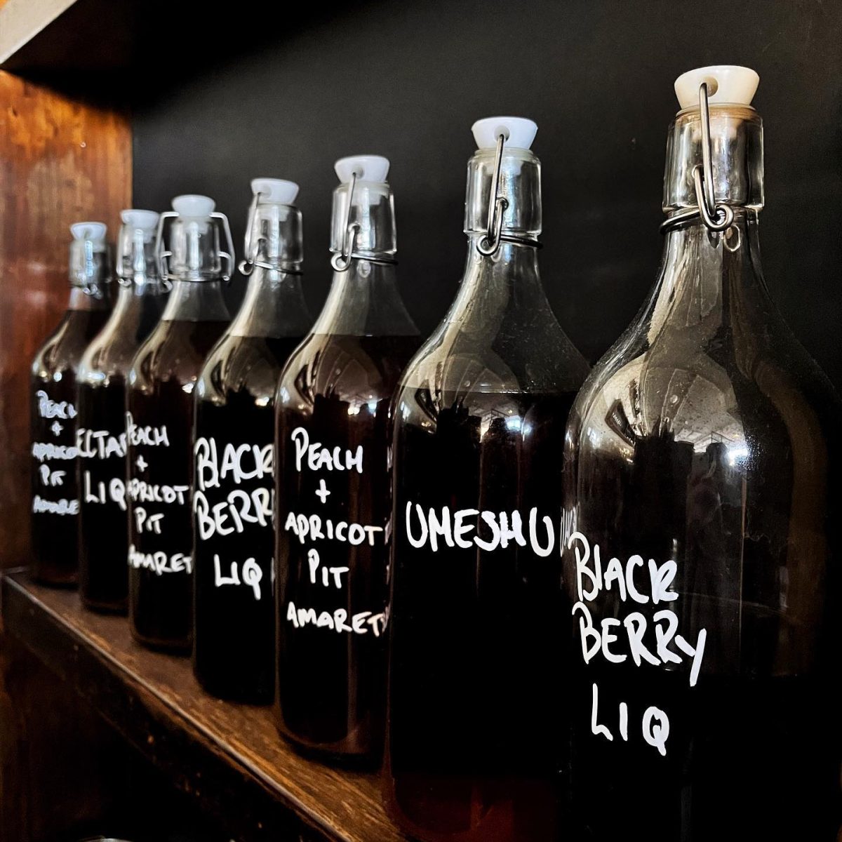 bottles of fruit liqueur labelled by hand