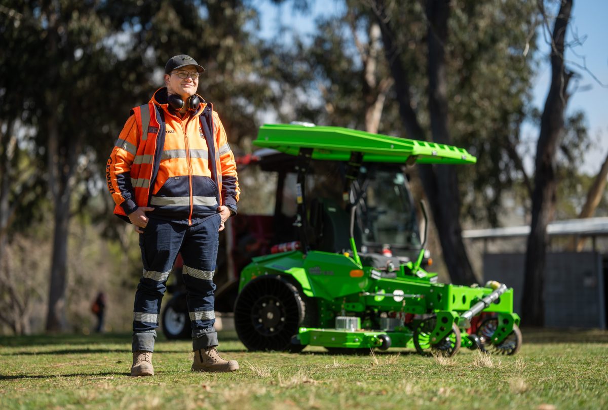 City Services mowing team member with electric mower