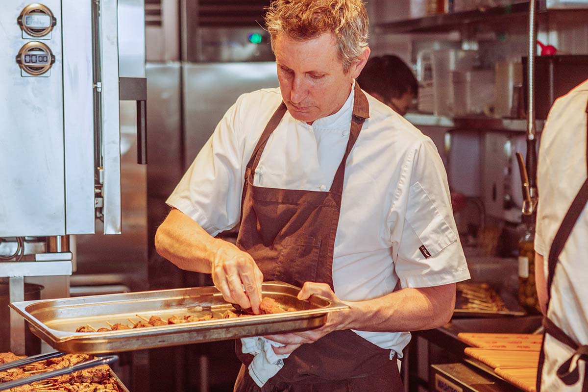 Ben Willis cooking food in Leyla Bar's new kitchen