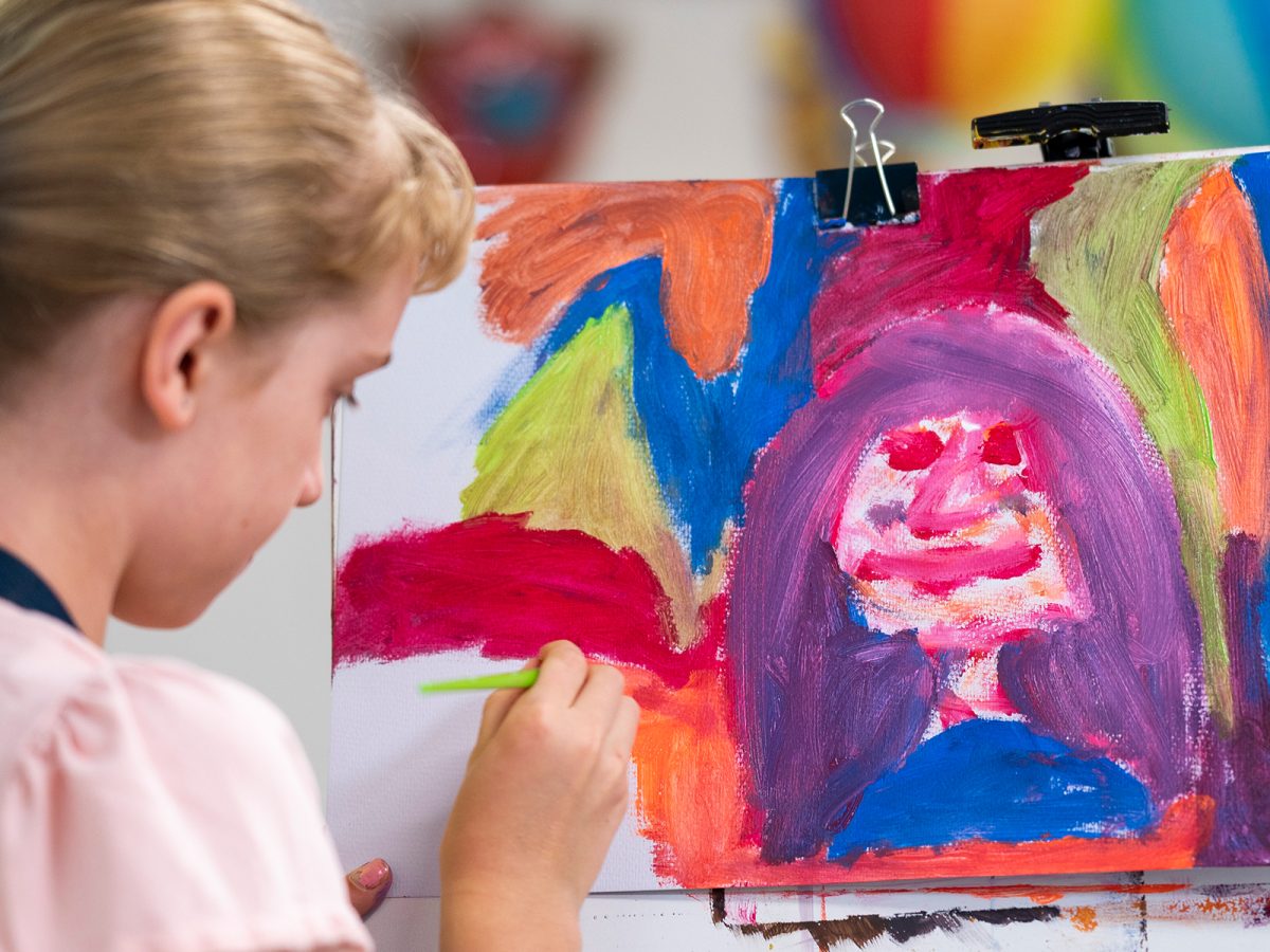 woman painting a face on canvas