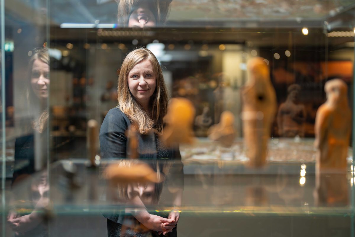 woman looking at glass case at the ANU Classics Museum