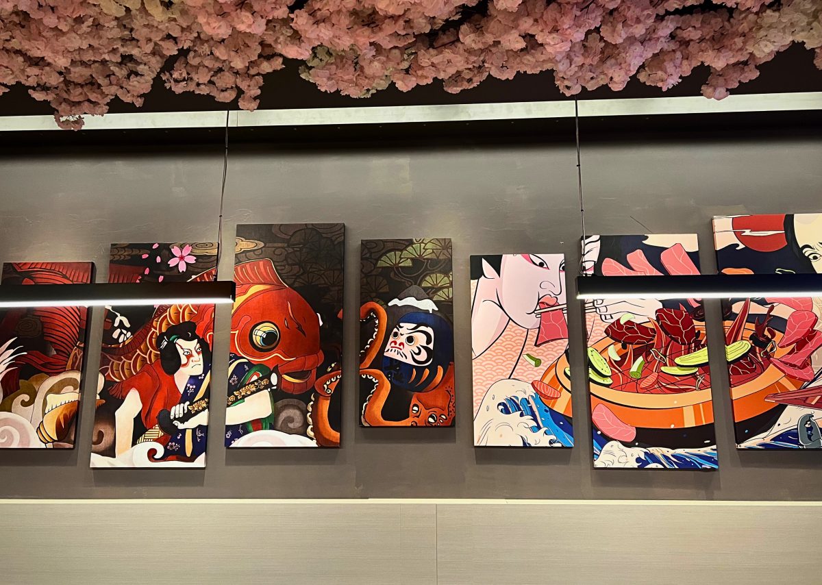 Quirky Japanese inspired artworks on a restaurant wall.