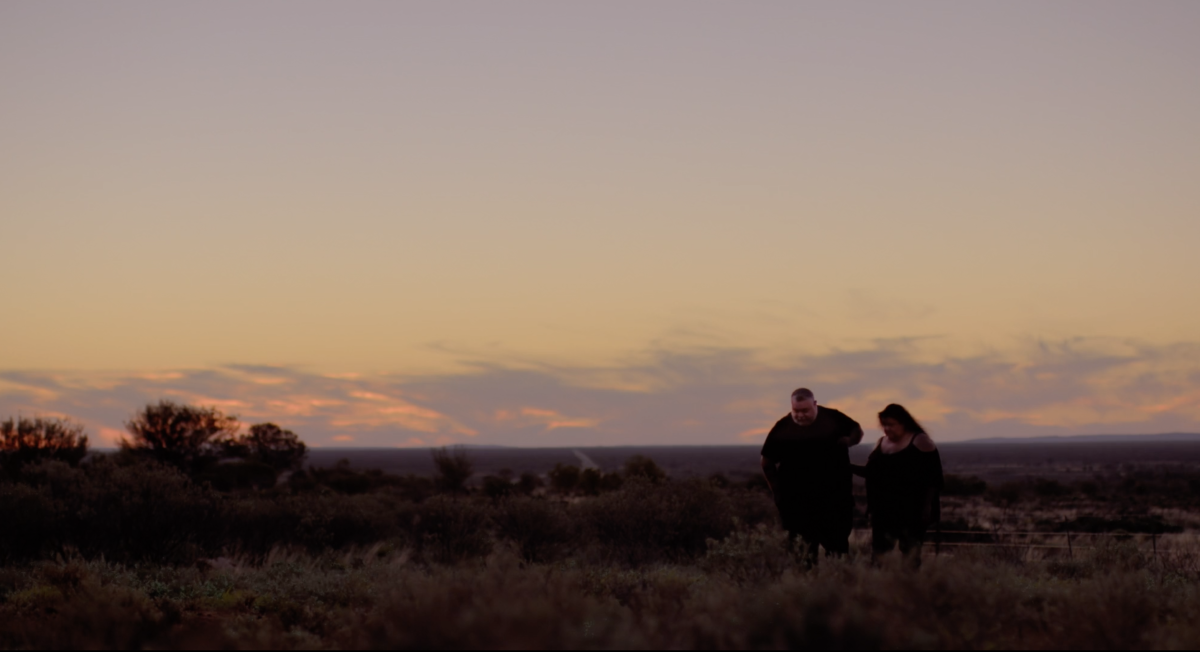 Man and woman walking in the bush at dusk