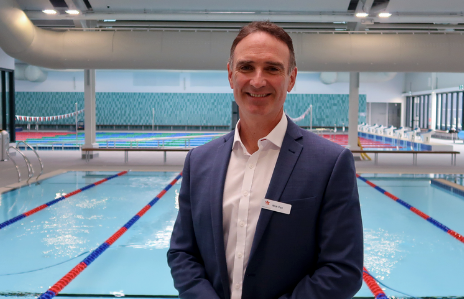 man in a suit standing near a pool