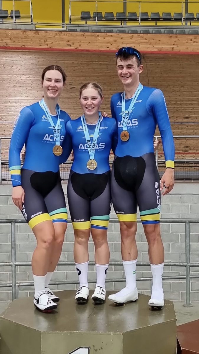 Claudia Marcks, Lauren Bates and Cameron Rogers at a velodrome with medals