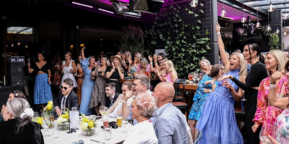 crowd dressed up and watching a tv screen