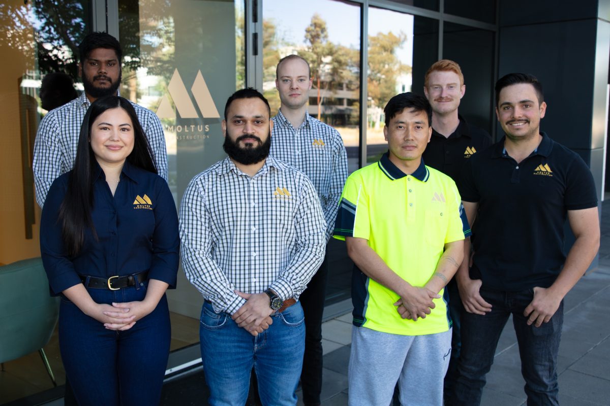 The team from Moltus Construction stand together outside their headquarters