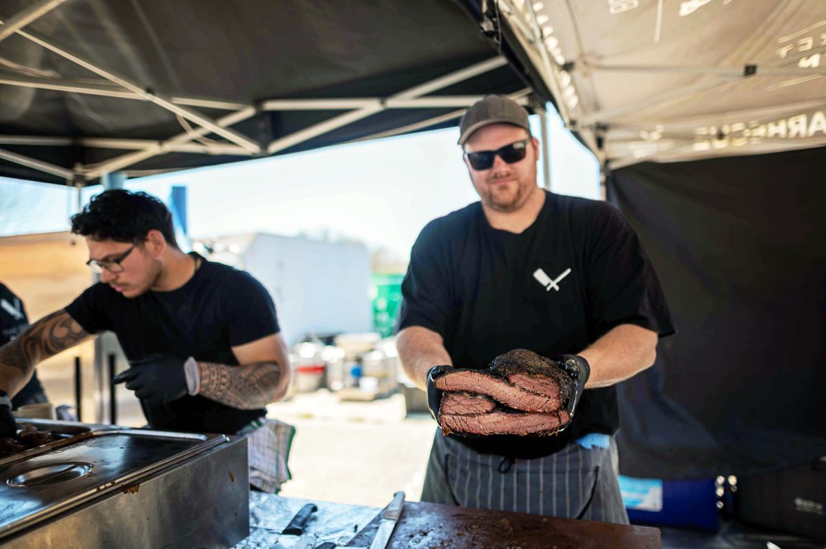 A man holds out smoked meat