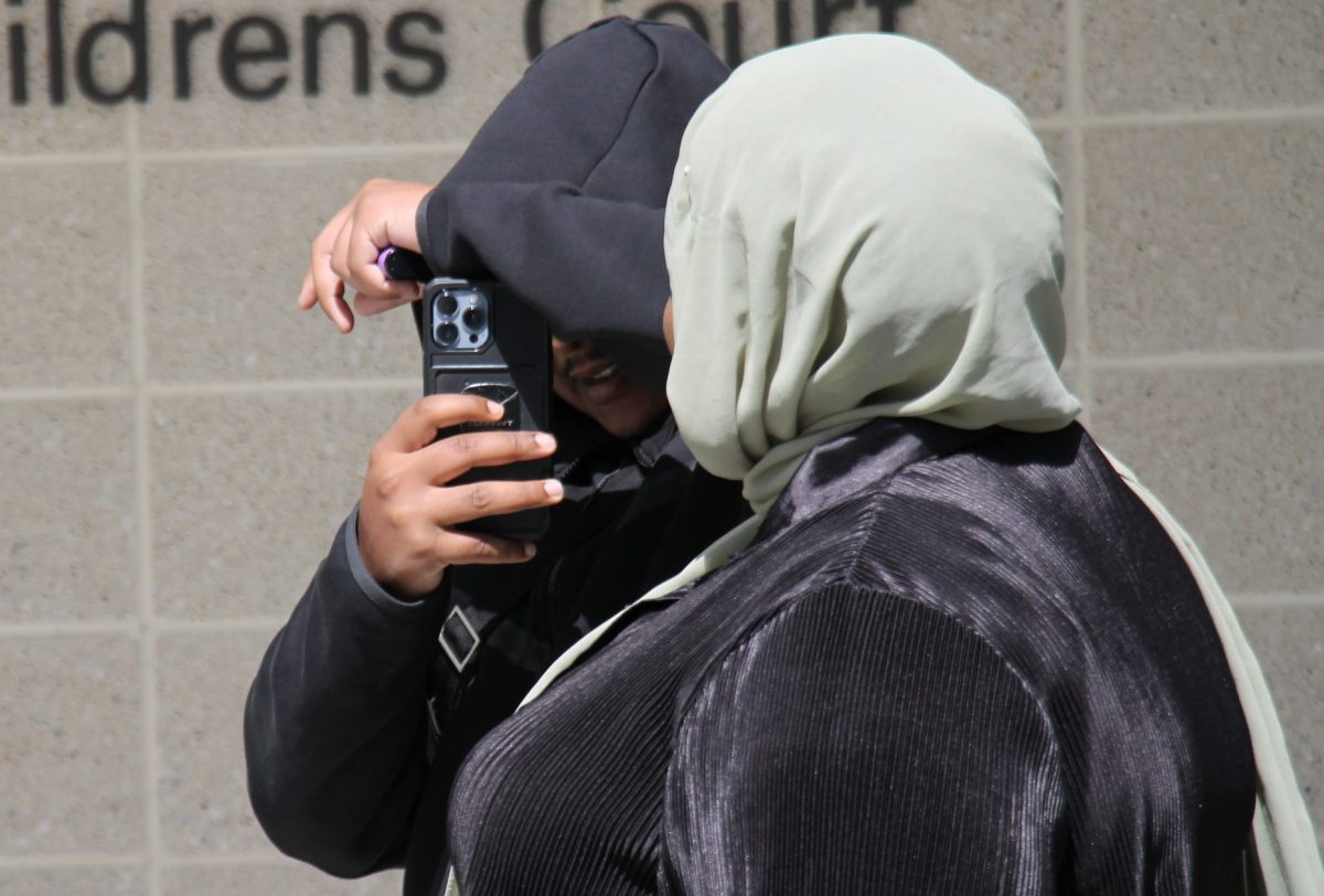 man and woman leaving court with their heads covered