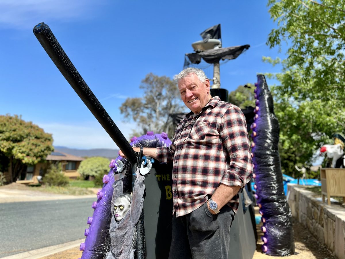 man standing with Halloween decorations