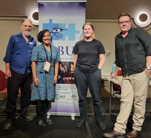 four people standing in front of a poster